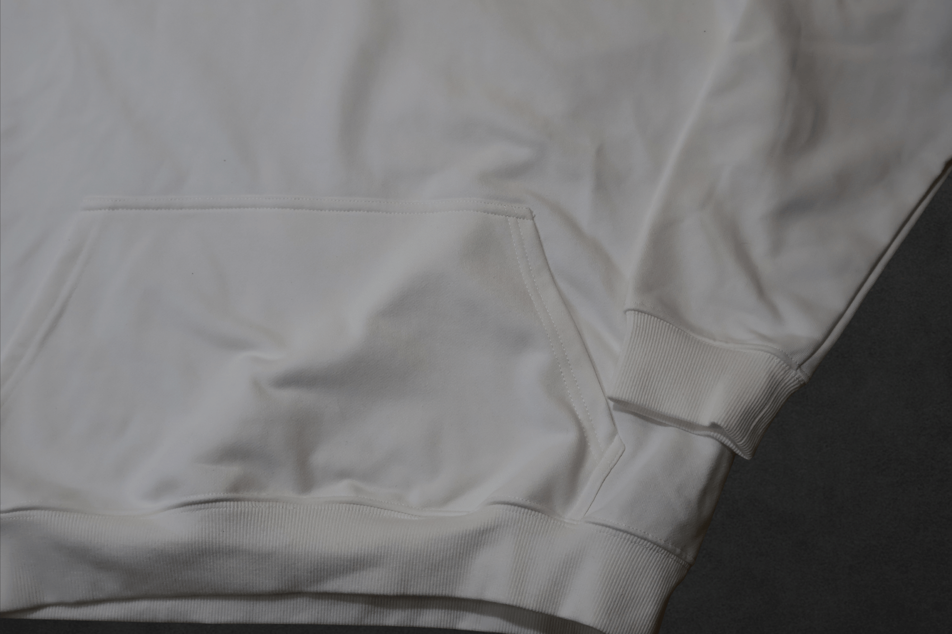 Close-up of the SR Black & White Premium Hoodie 450g - Unisex showing the pocket and cuff details in soft white fabric.