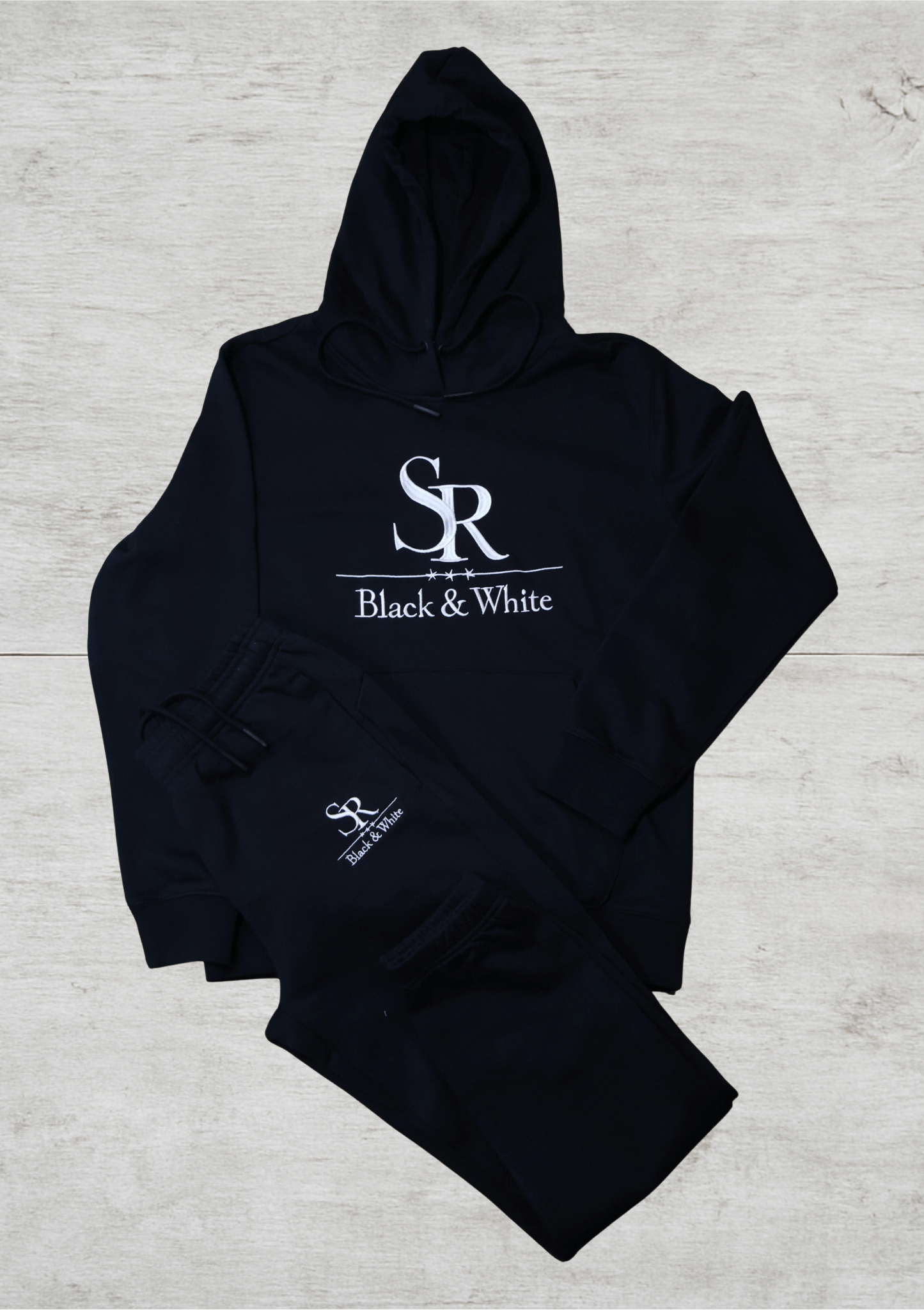 SR Black & White Black Tracksuit – Unisex featuring a black hoodie and joggers with embroidered logo, made from premium cotton.